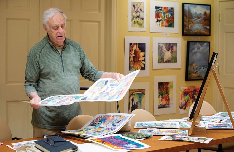 Resident looks over his artwork pieces.