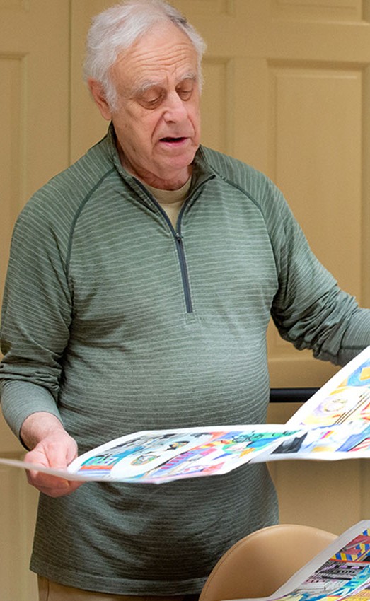 A man looks over his collection of artwork.