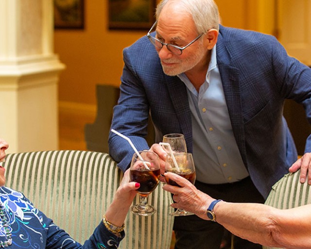 Three people clinking their glasses together in a toast.