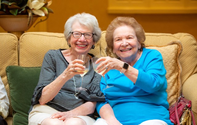 Two women toasting their glasses.