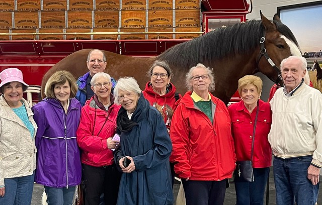 Residents standing in front of a horse on a tour.