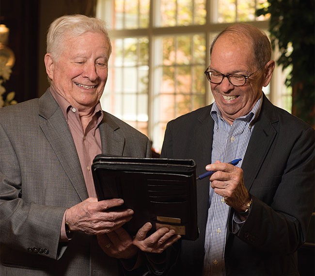 Two men looking at a tablet.